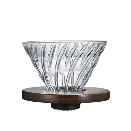 Clear glass coffee dripper with wooden base on a white background