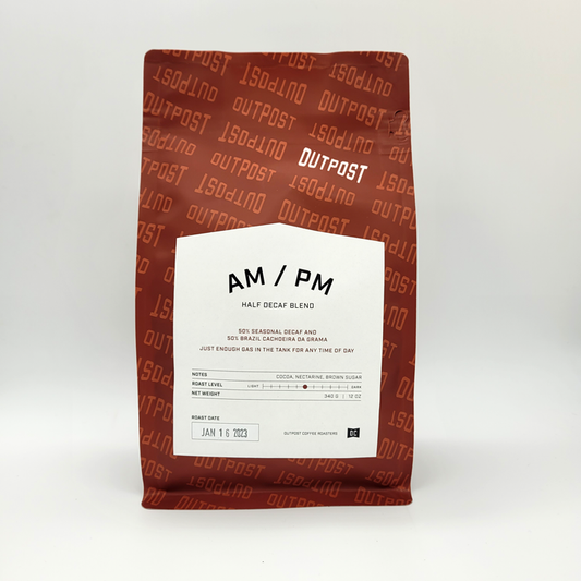 A packaged bag of AM/PM Half Decaf Blend coffee with branding and product information on the label.